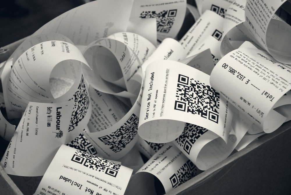 A tangled pile of curled paper receipts waiting to be entered